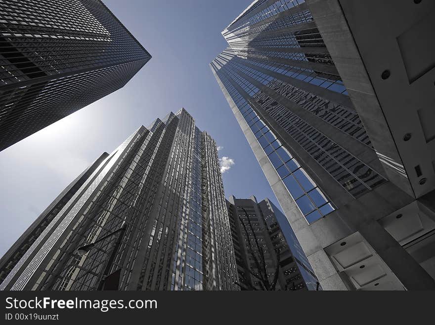 A group of soaring office towers, shaded in blue and grey. A group of soaring office towers, shaded in blue and grey.