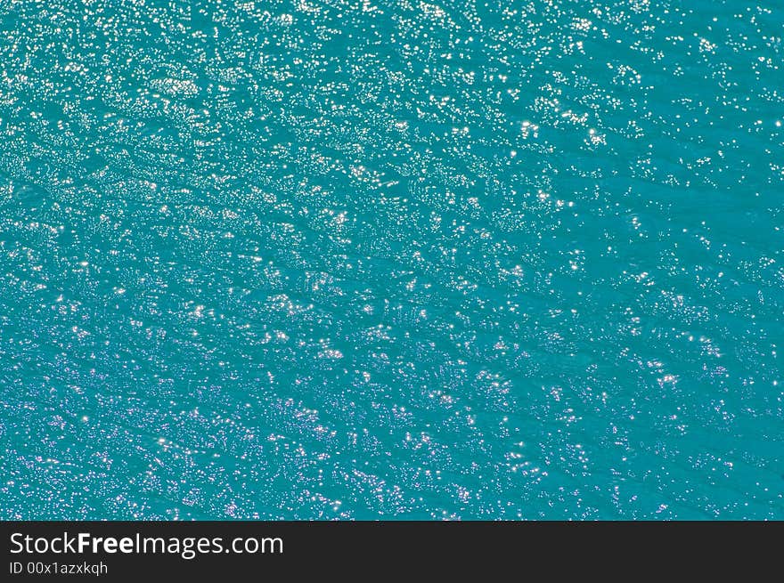 Bright shiny pattern of sun bouncing off the surface of a pool.