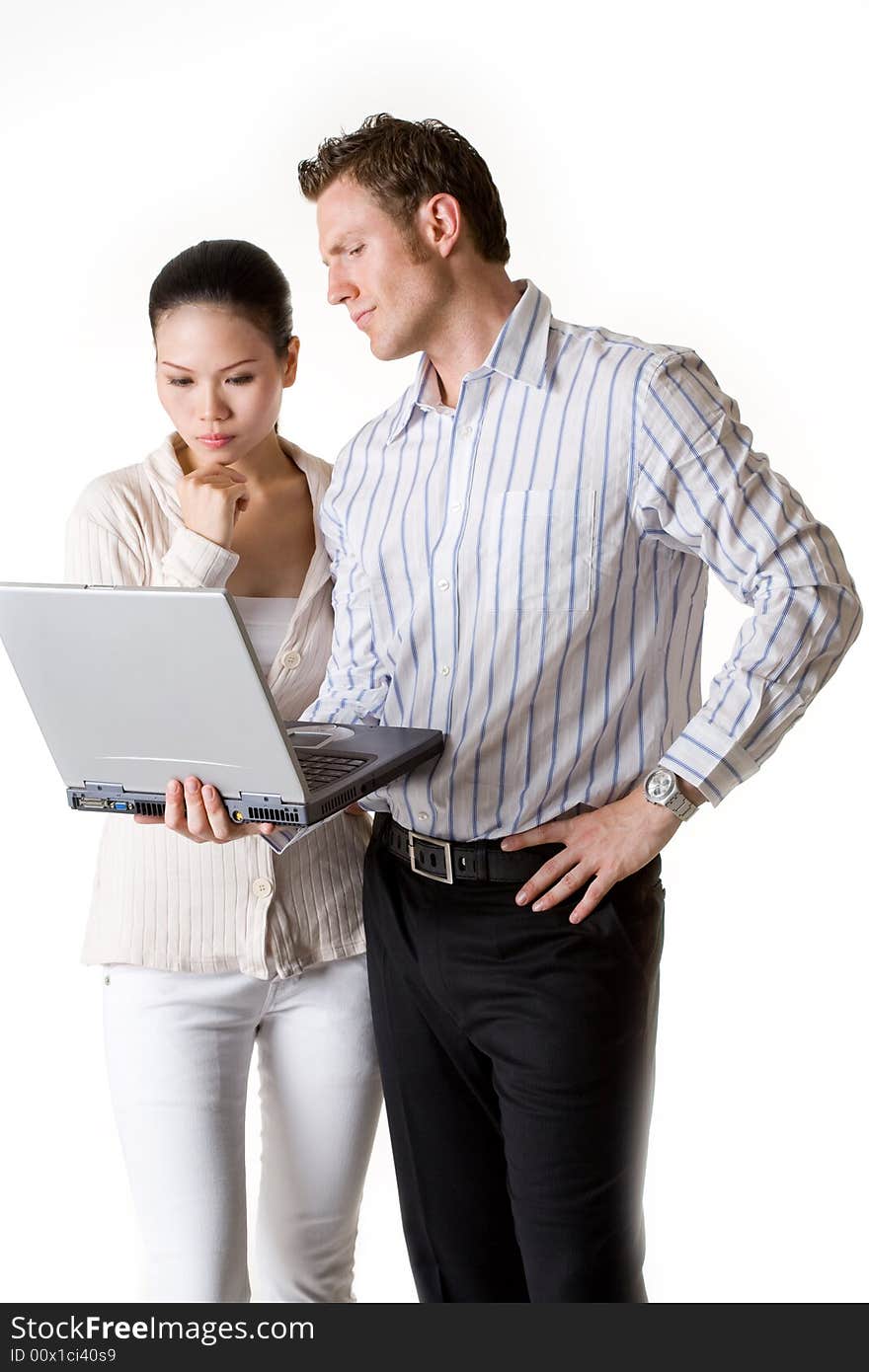 A businesswoman and businessman get thier mind focused on an important document from their notebook. A businesswoman and businessman get thier mind focused on an important document from their notebook