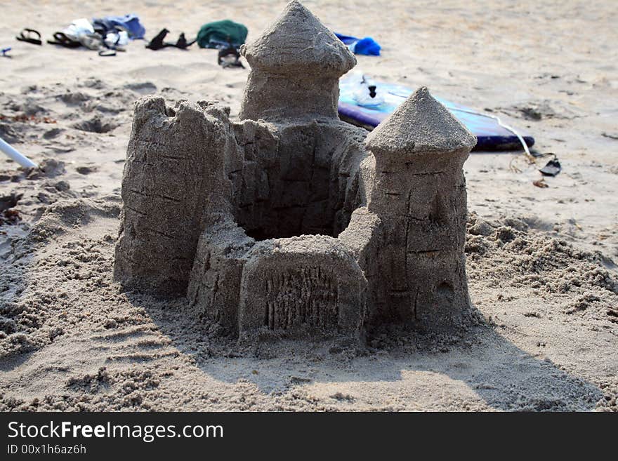 Sand castle on beach with beach supplies in background