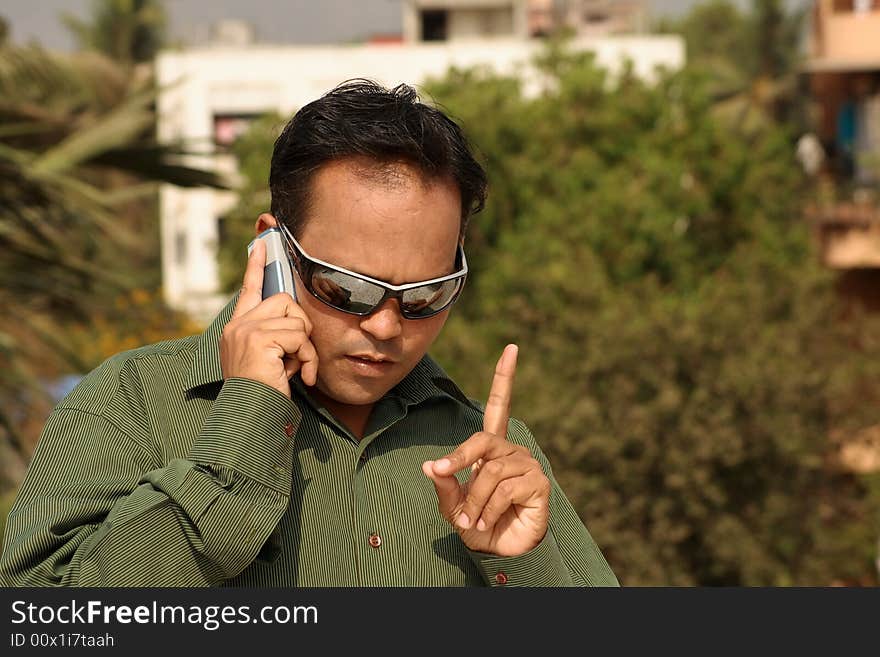 A young man giving instructions over the phone. A young man giving instructions over the phone.