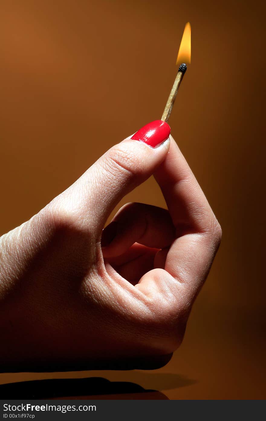 A female hand is holding a burning matches