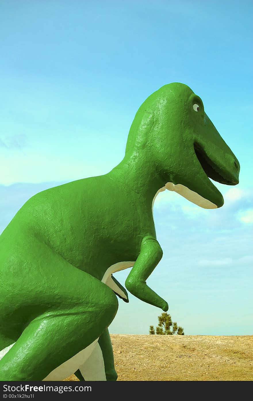 A big green dinosaur walking through the land.