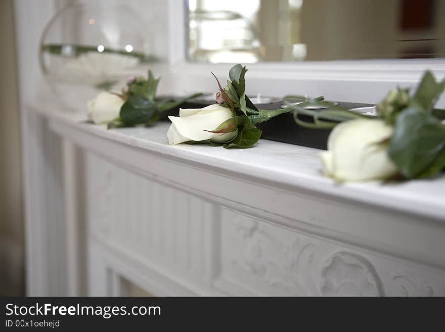 Three white roses on the fireplace