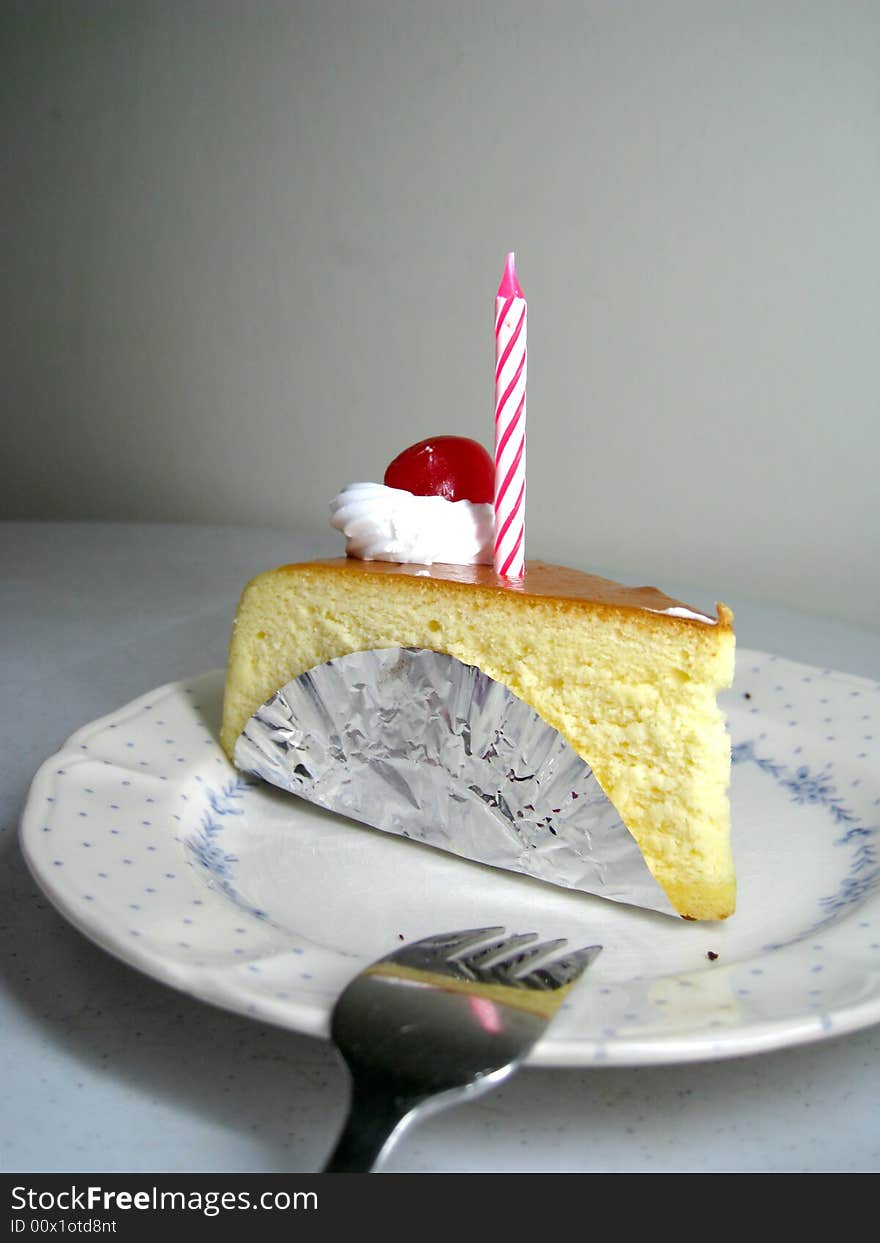 A slide of cheese cake with candle on top