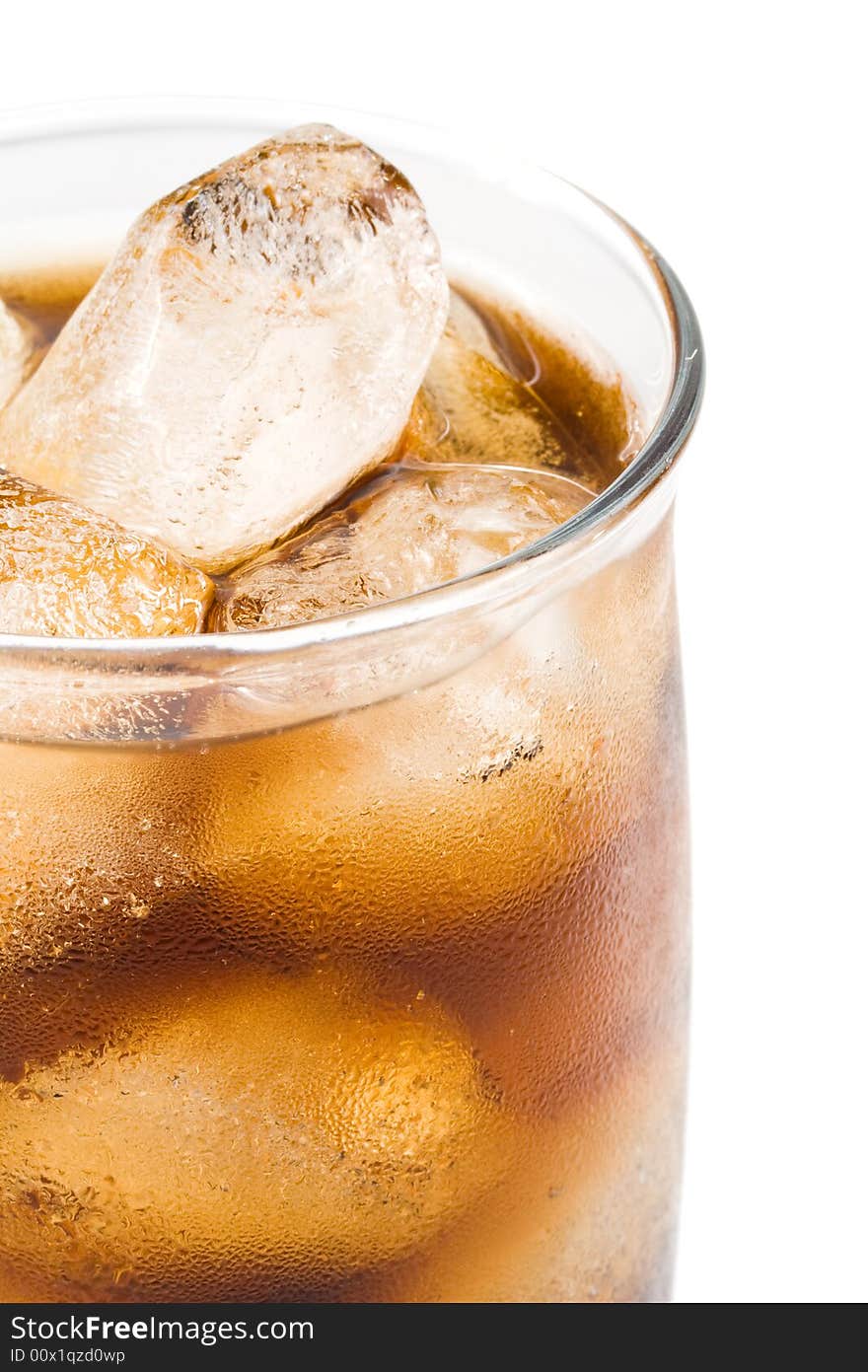 Cold fizzy cola with ice in a glass. Close up.