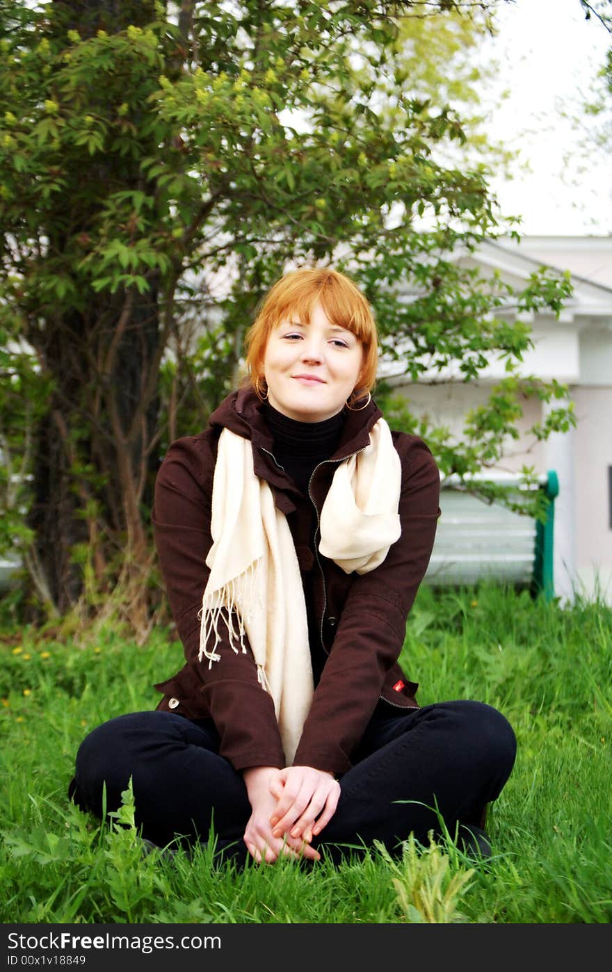 Girl sitting cross-legged in a garden. Girl sitting cross-legged in a garden