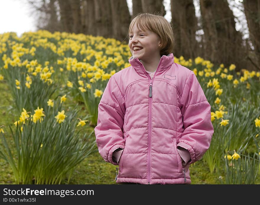 Girl outdoors against a backdrop of yellow daffodils. Girl outdoors against a backdrop of yellow daffodils