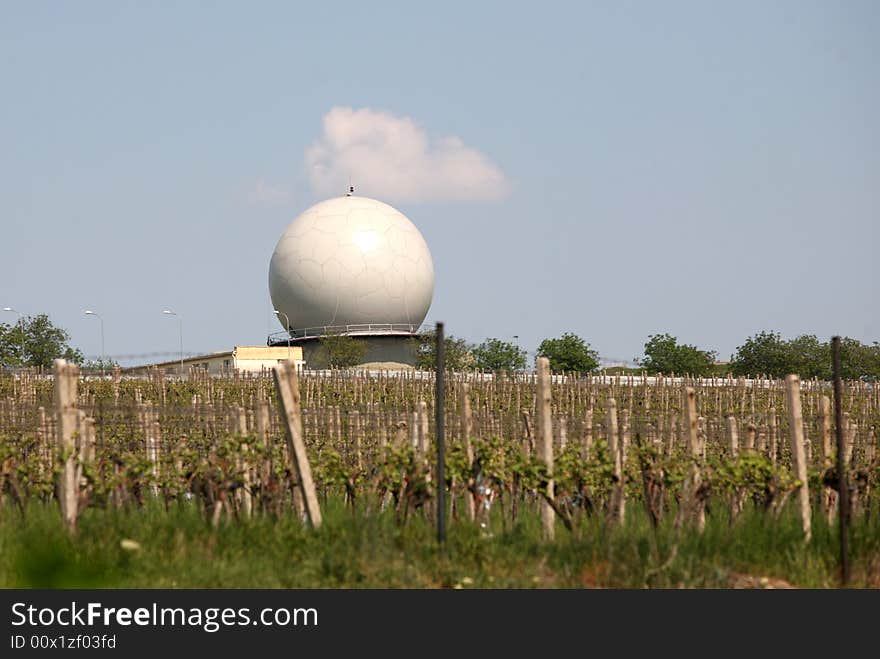 A landscape with an army radar and a vineyard in the front