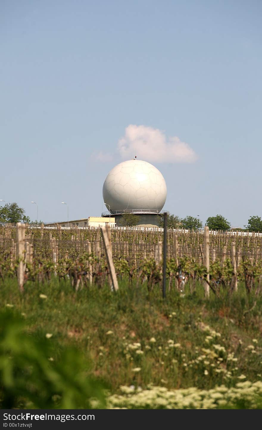 A landscape with an army radar and a vineyard in the front