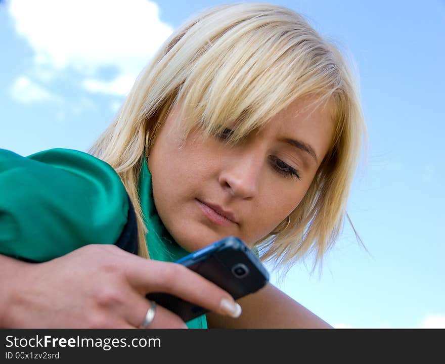 Cute blonde messaging on the blue sky background