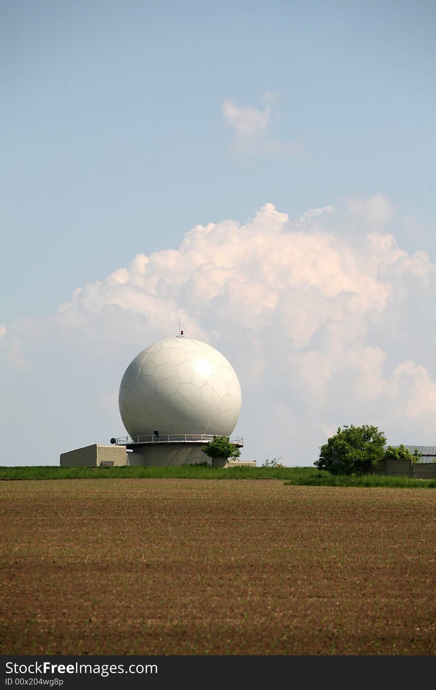 A landscape with an army radar and a field in the front