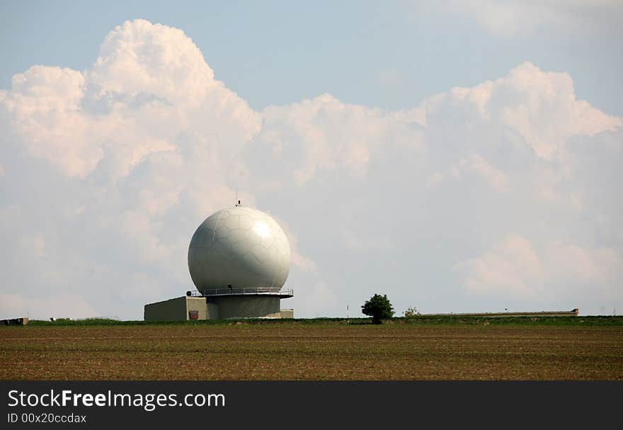 A landscape with an army radar and a field in the front