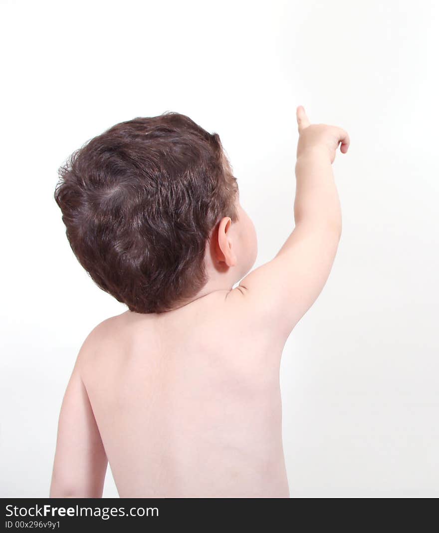 3 year old boy facing wall and pointing up. 3 year old boy facing wall and pointing up