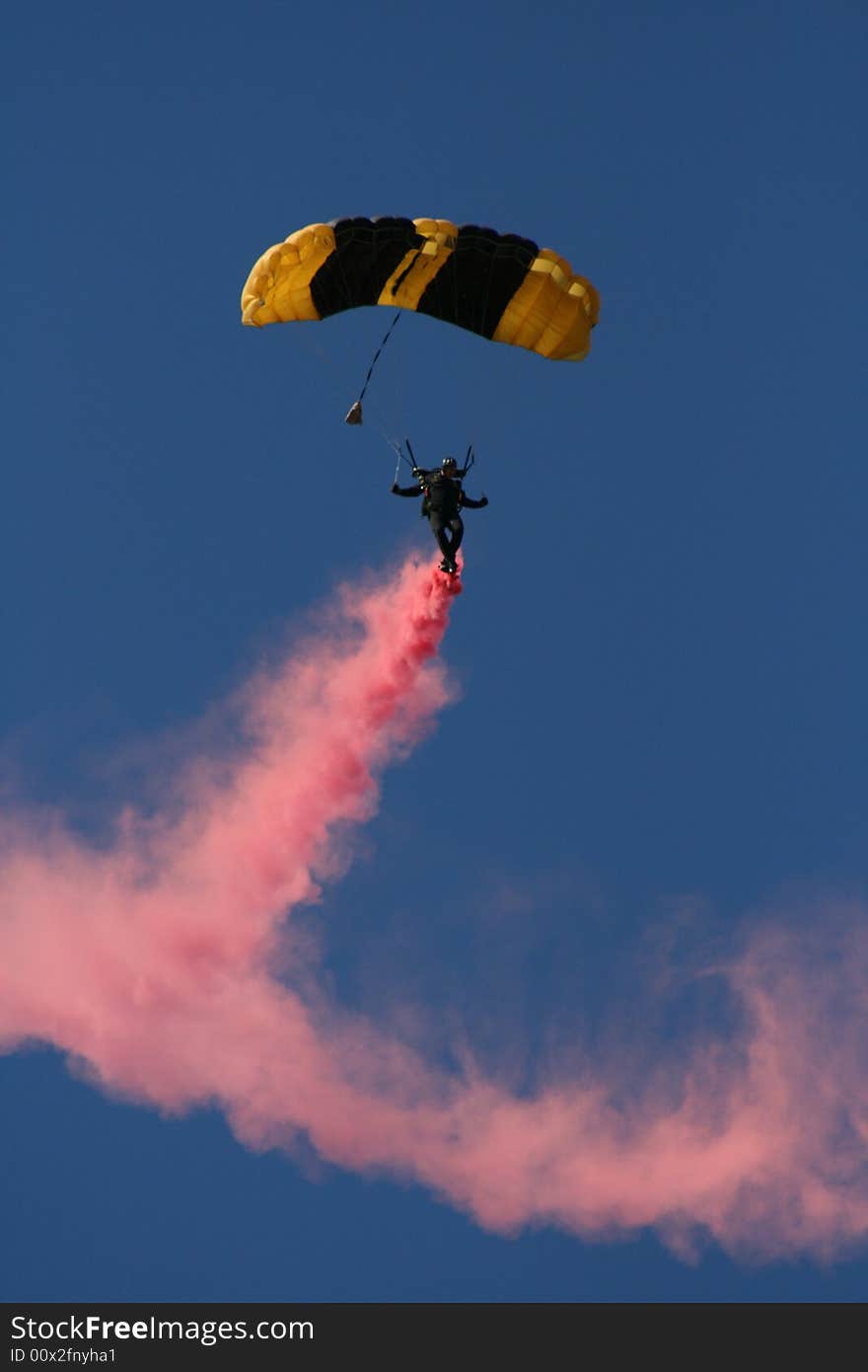 Skydiver in mid-air with colored smoke flowing behind him. Skydiver in mid-air with colored smoke flowing behind him.