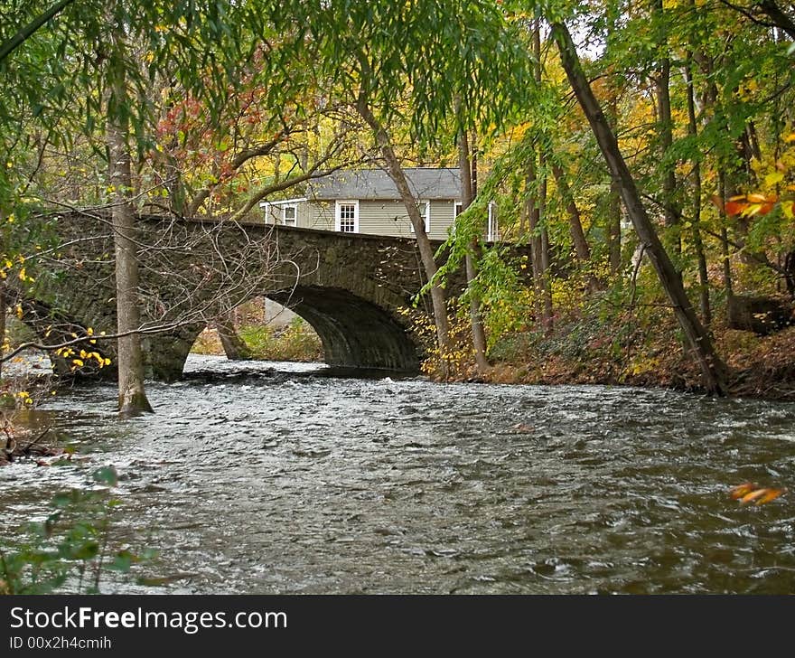 An old stone bridge over a wooded stream in the scenic Pocono Mountains of Pennsylvania.