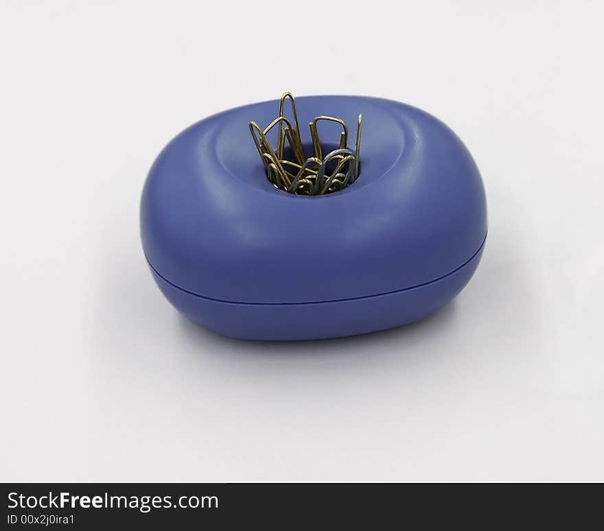 Metal paper clips in a blue plastic magnetic paper clip dish.