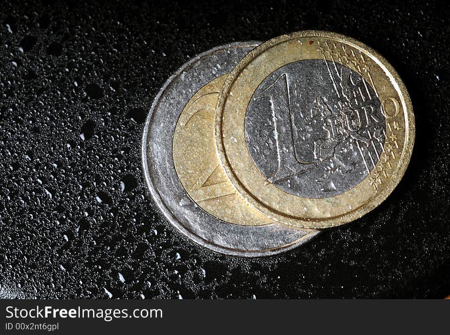 A view with a coins on a wet black background