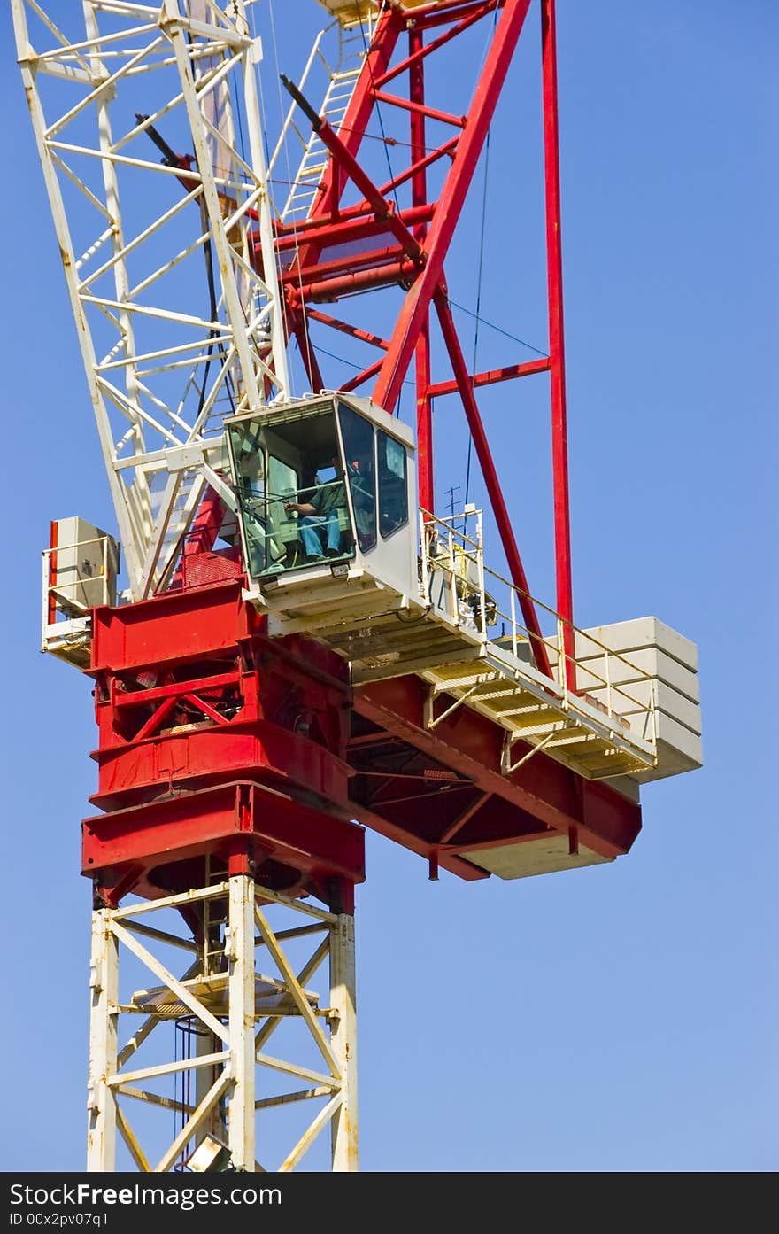 Construction crane busy at work on a sunny day with blue sky