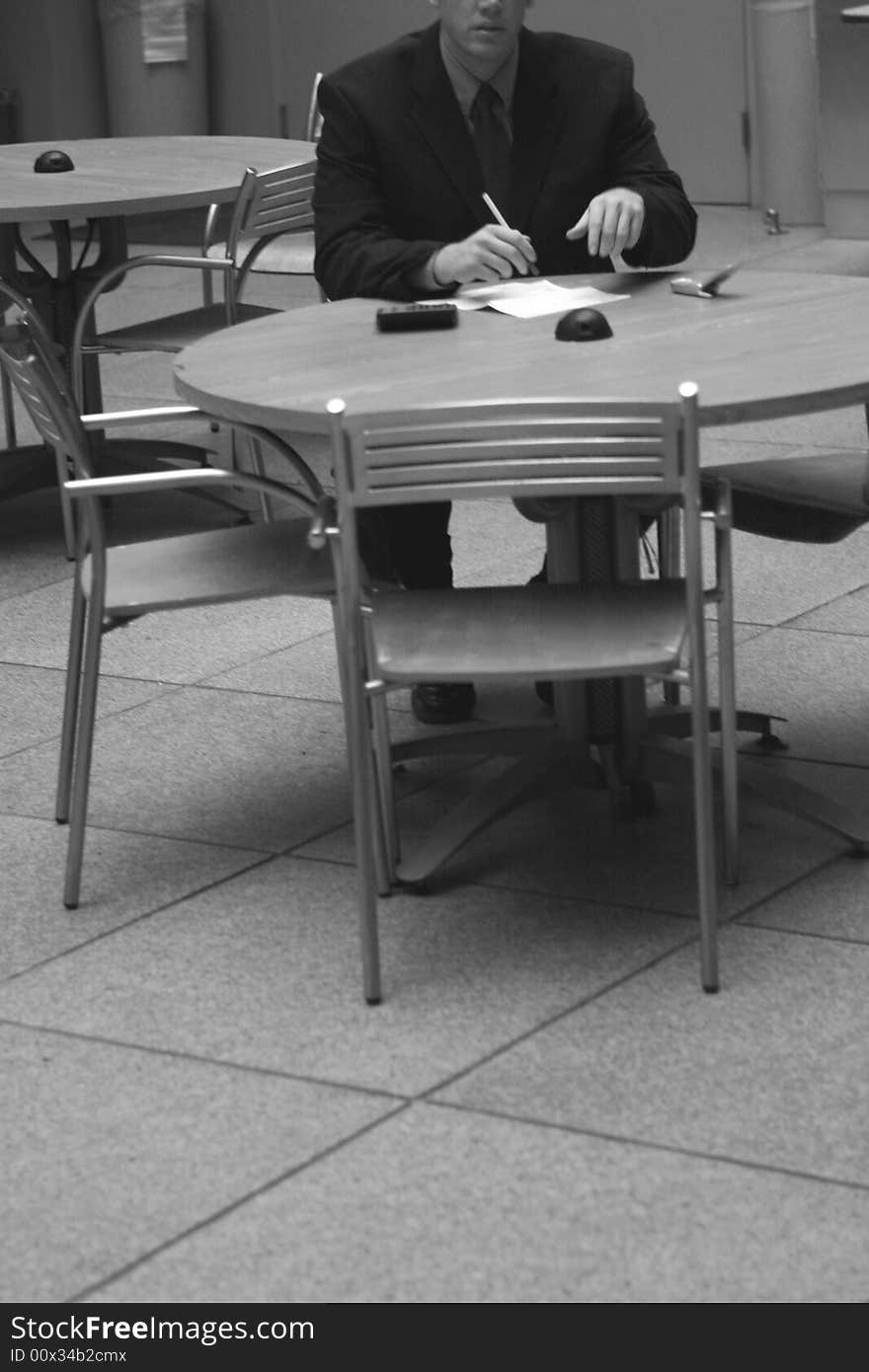 Businessman sitting at table going over the numbers. Businessman sitting at table going over the numbers