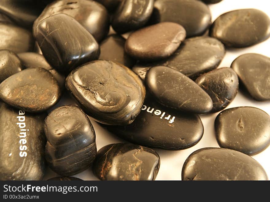 Black pebbles on a white background (shallow DOF)