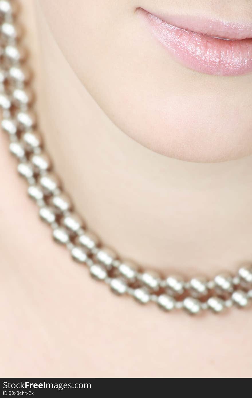 Close up of lips and teeth of a smiling woman with a necklace. Close up of lips and teeth of a smiling woman with a necklace