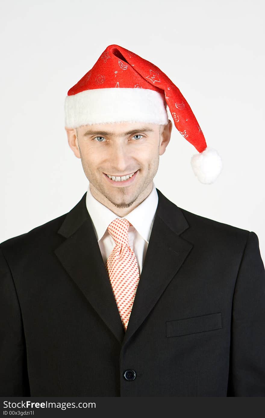 A smiling businessman wearing Santa Claus hat, white background. A smiling businessman wearing Santa Claus hat, white background.