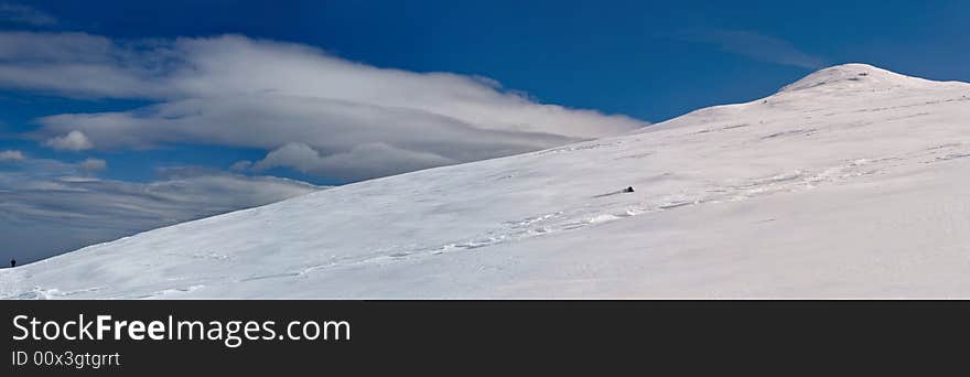 Snowy white mountain slope with blue sky panorama. Snowy white mountain slope with blue sky panorama