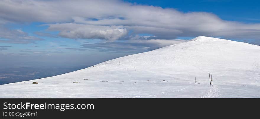 Snowy white mountain slope with blue sky panorama. Snowy white mountain slope with blue sky panorama