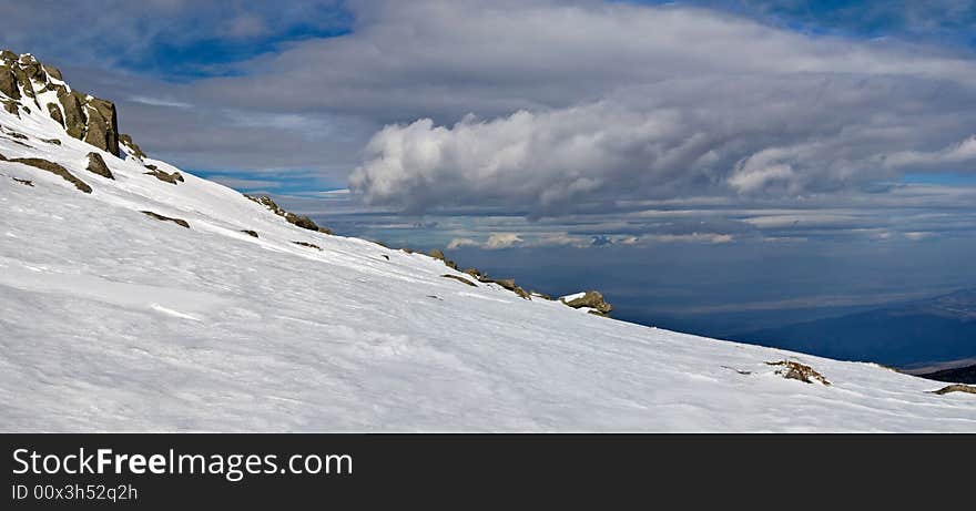 Snowy white mountain slope with blue sky panorama. Snowy white mountain slope with blue sky panorama