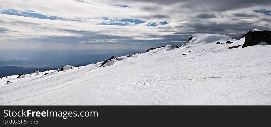 Snowy white mountain slope with blue sky panorama. Snowy white mountain slope with blue sky panorama