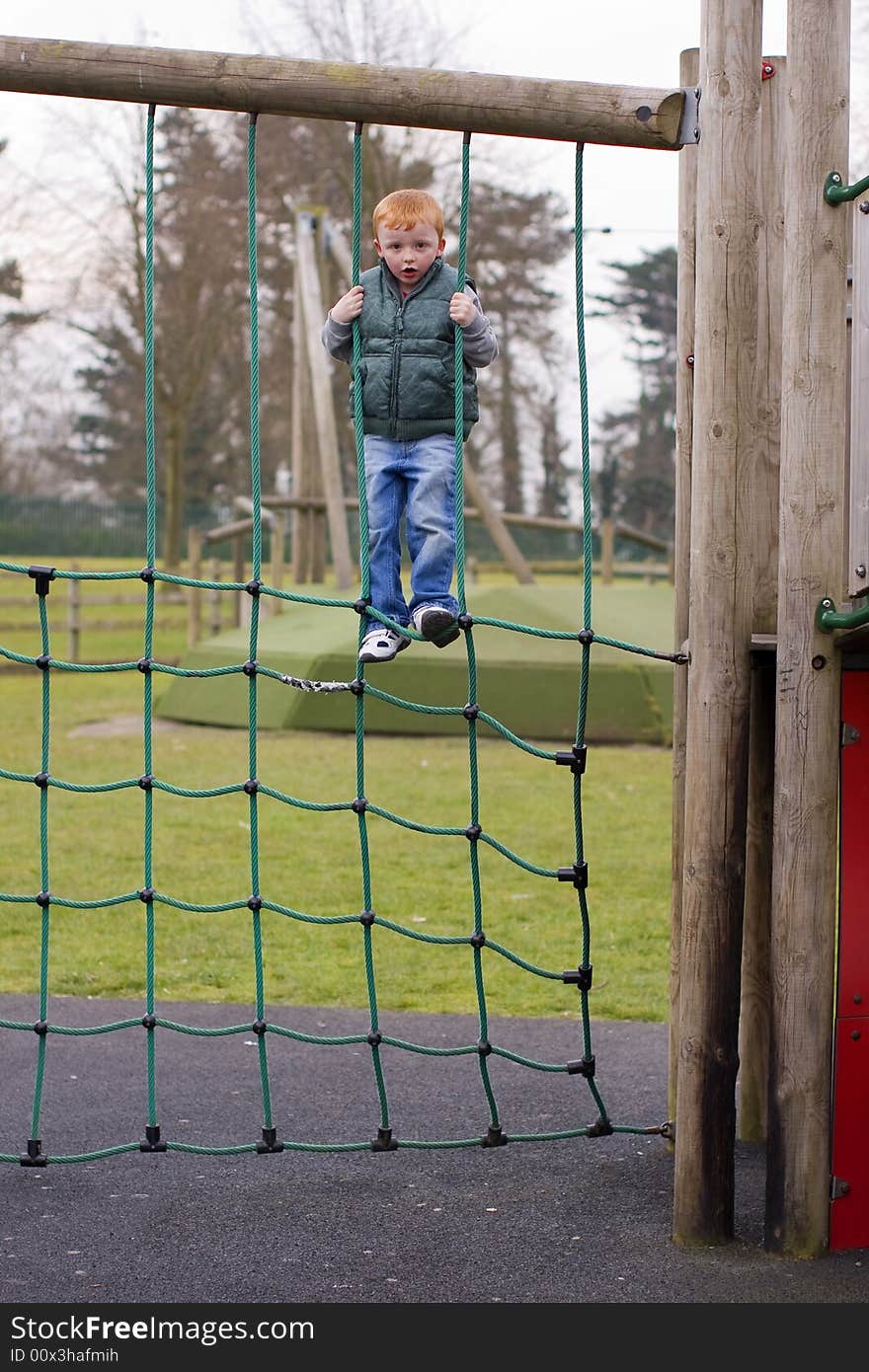 Boy climbing ropes in a play park. Boy climbing ropes in a play park