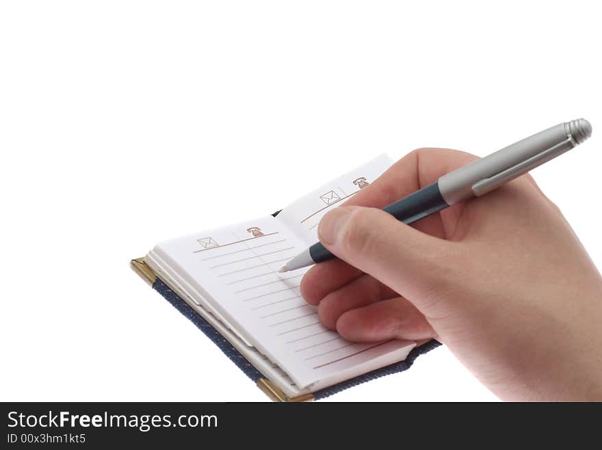 The hand writes a ball pen in a notebook, on a white background. The hand writes a ball pen in a notebook, on a white background