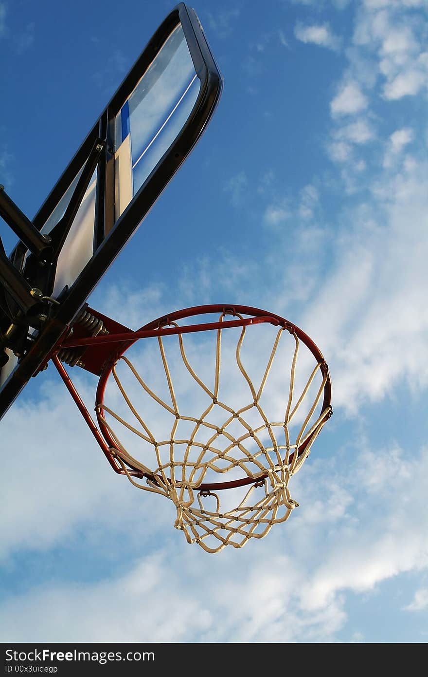 Basketball hoop against a blue sky. Sharp focus over entire image. Basketball hoop against a blue sky. Sharp focus over entire image.