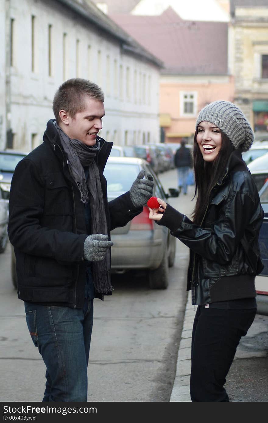 Young man offering a ring gift box to an attractive girl. Young man offering a ring gift box to an attractive girl