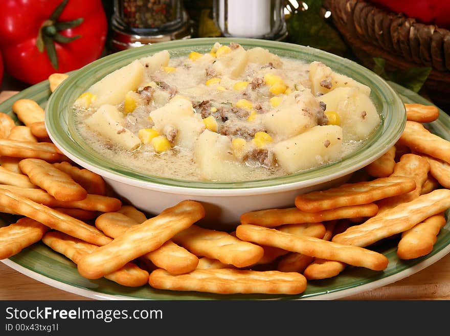 Bowl of beef chowder in bowl with crackers.