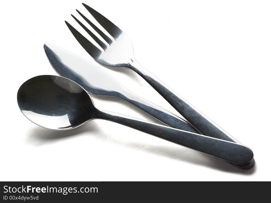 Spoon, knife and fork on the white background with shadow. Spoon, knife and fork on the white background with shadow.