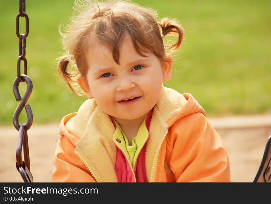 Little girl at park playground. Green grass  background. Spring time. Little girl at park playground. Green grass  background. Spring time.