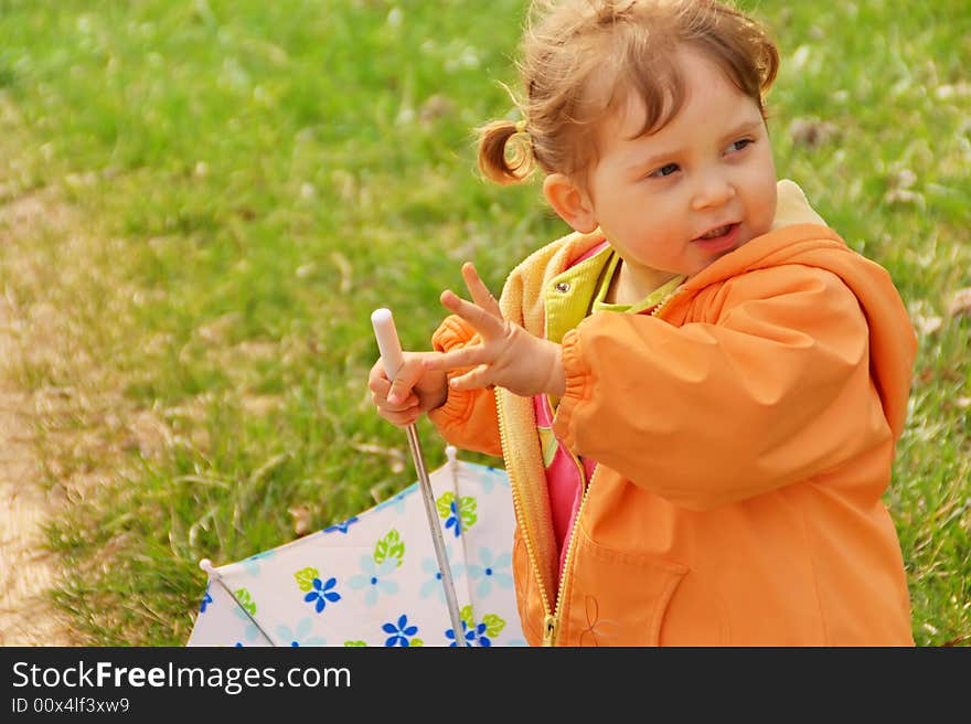 Little girl playing with umbrella at park. Green grass  background. Spring time. Little girl playing with umbrella at park. Green grass  background. Spring time.