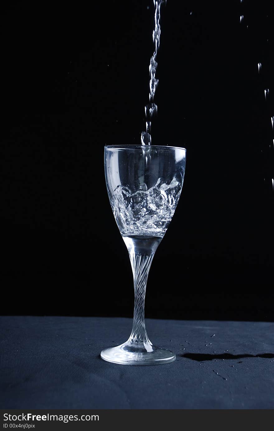 Water splashing in glass at black background. Water splashing in glass at black background