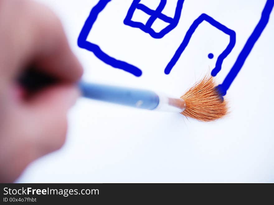 Man painting house on white paper by brush