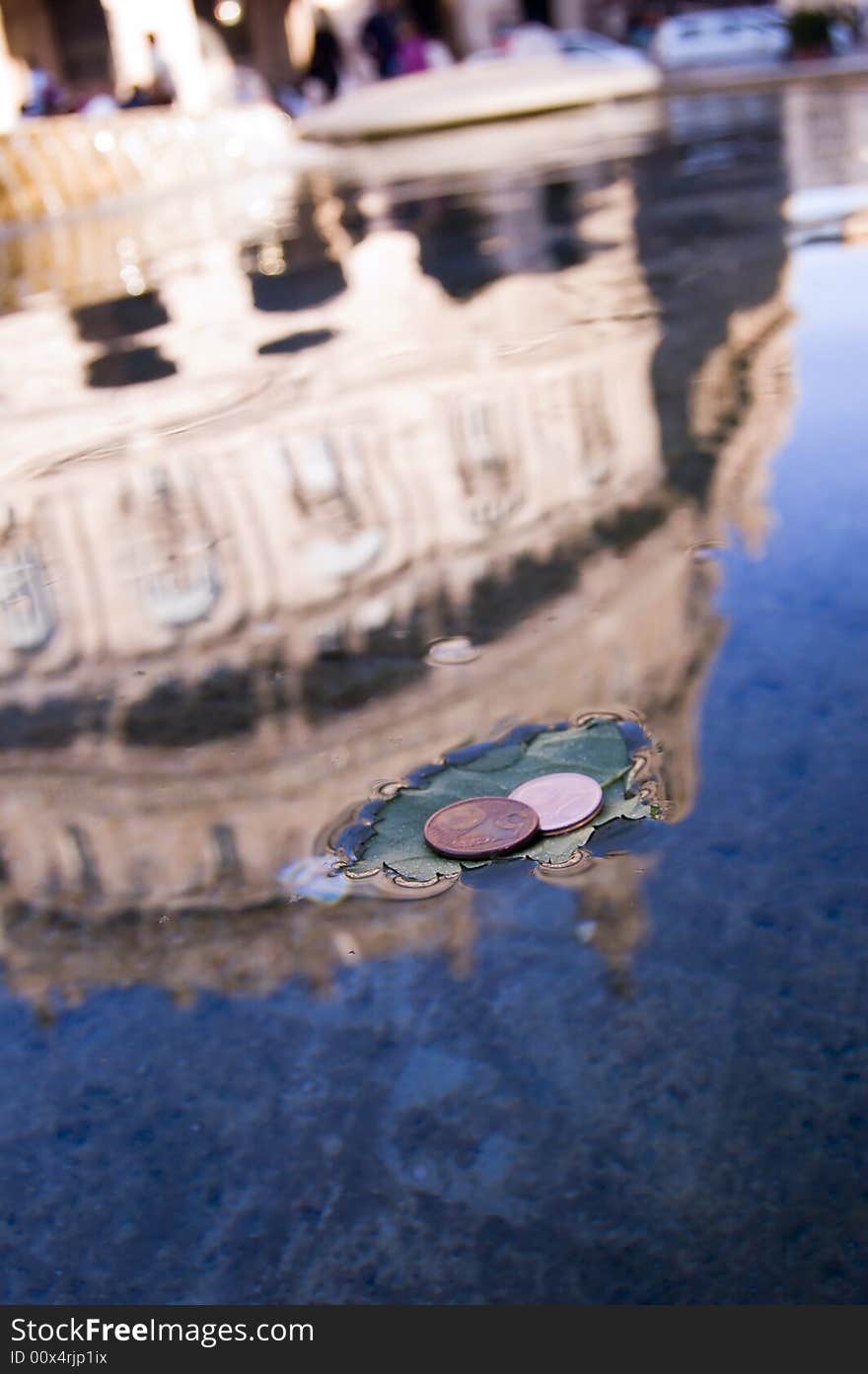 Coins on a leaf in a fountain in Piazza De Ferrari,  Genoa, italy. Coins on a leaf in a fountain in Piazza De Ferrari,  Genoa, italy