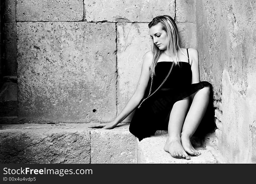 Young sad woman in elegant black dress.