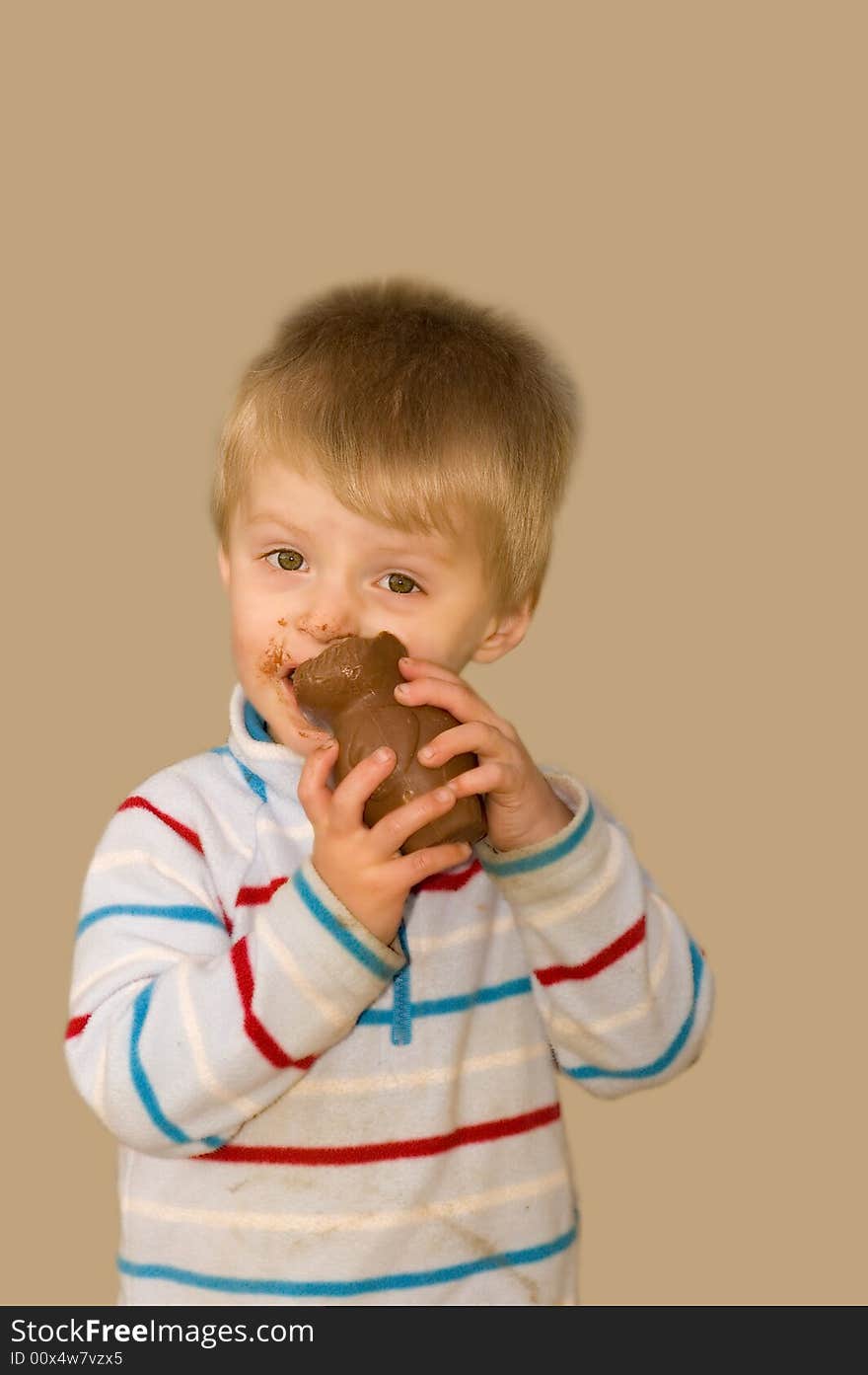 Messy toddler eating and enjoying an easter egg. Messy toddler eating and enjoying an easter egg.