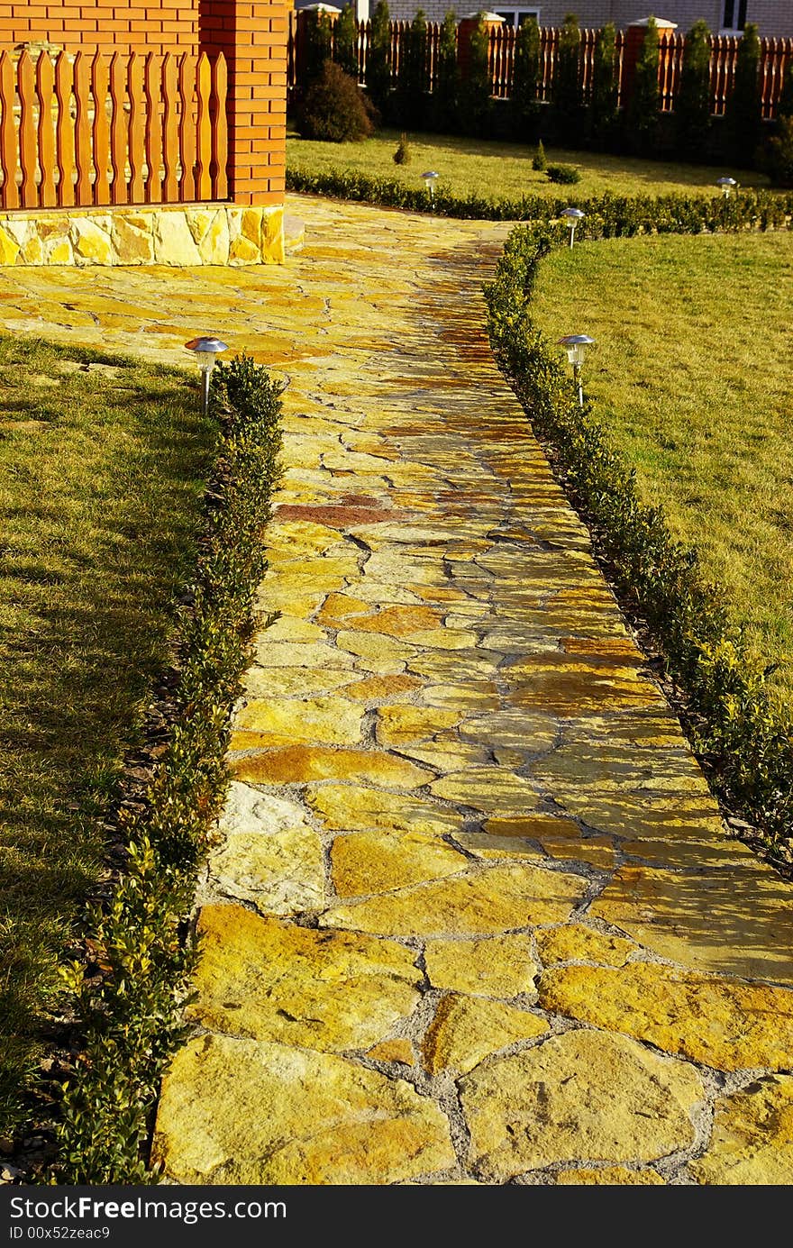 Garden stone path with grass growing up between the stones. Garden stone path with grass growing up between the stones