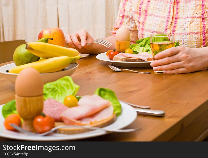 Woman eating snacks. Fruits, vegetables, bread, egg, ham etc. Focus on the person. Woman eating snacks. Fruits, vegetables, bread, egg, ham etc. Focus on the person.