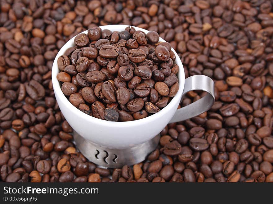 Cup of coffee beans on coffee beans background