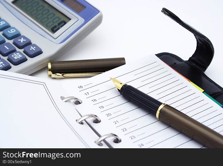 Notepad, pen and calculator on white background.