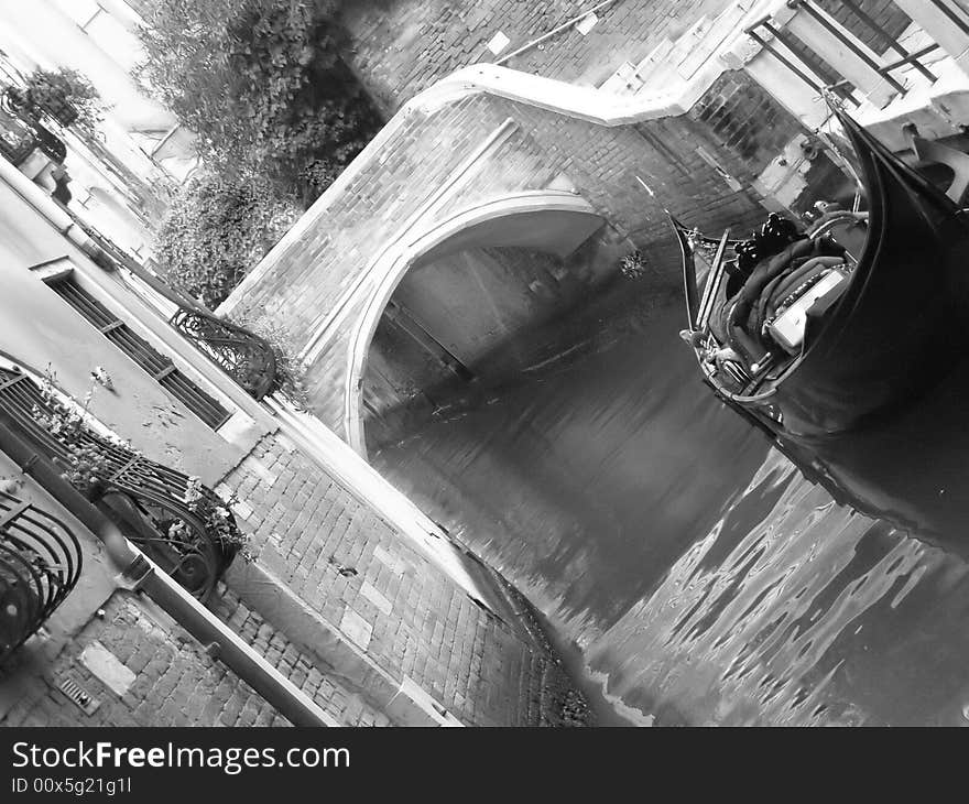 Venice (Italy) postcard: a quiet canal corner in Venice with gondola, brick bridge and palace facade with flowers;  black and white image. Venice (Italy) postcard: a quiet canal corner in Venice with gondola, brick bridge and palace facade with flowers;  black and white image