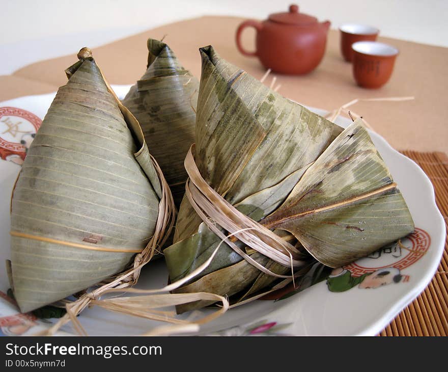 A pyramid-shaped mass of glutinous rice wrapped in leaves, one culture occasion in Chinese